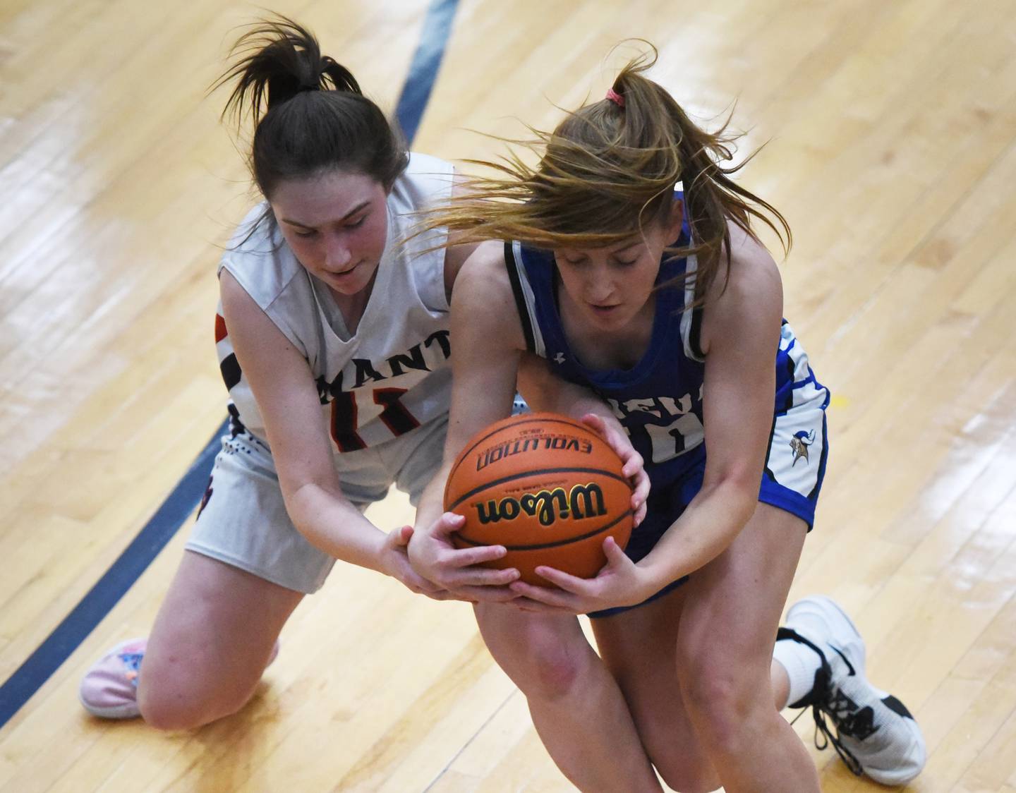 Conant's Lauren Fricke, left, and Geneva's Caroline Madden wrestle for the loose ball during Friday’s IHSA Class 4A girls basketball regional championship in Hoffman Estates.