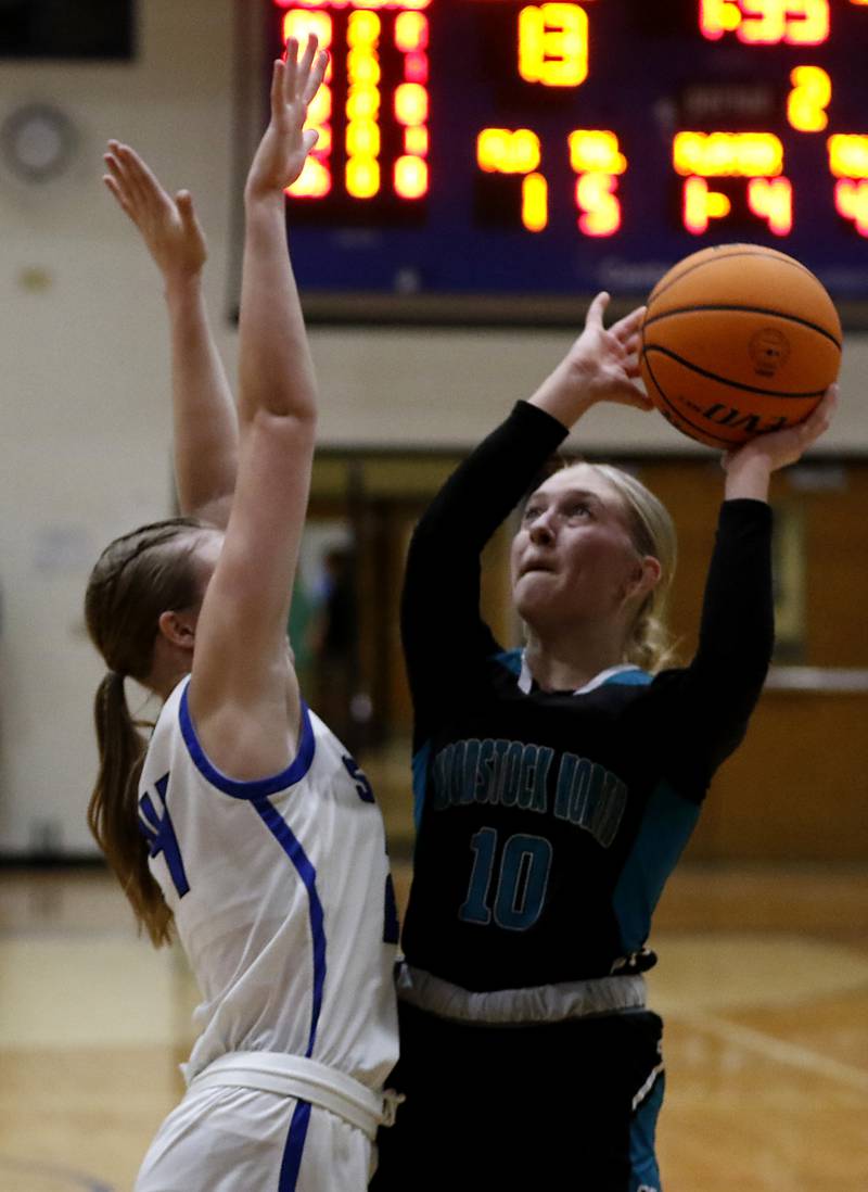 Woodstock North's Madalynn Nordahl (right) tries to shoot the ball over Woodstock's Hayden Williams during a Kishwaukee River Conference basketball game on Friday, Jan. 10, 2025, at Woodstock High School.