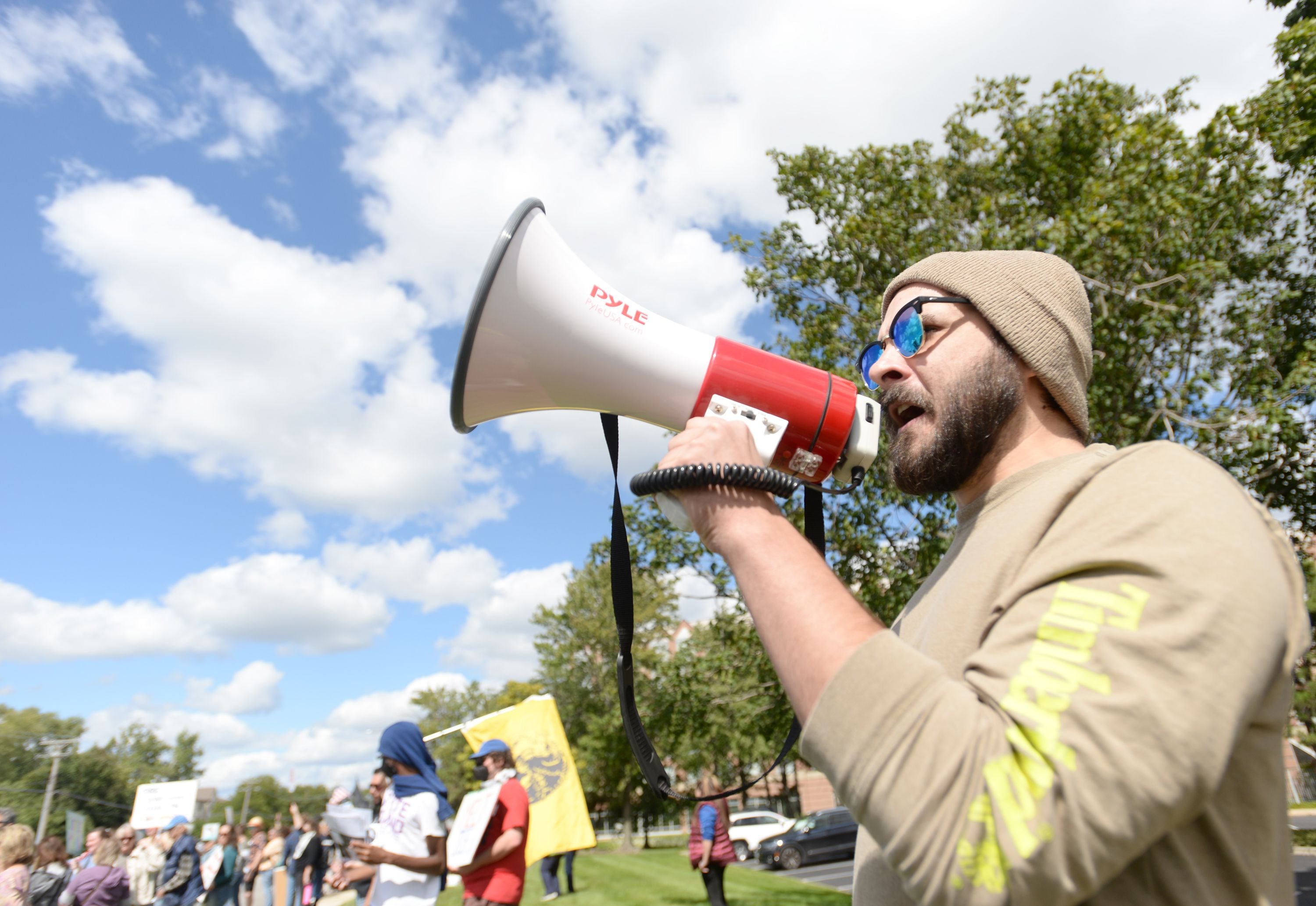 Sean Rowe of Bensenville leads demonstrators in chants Sept. 7 during a protest outside the Hampton Inn & Suites in Downers Grove where ICE agents are staying.