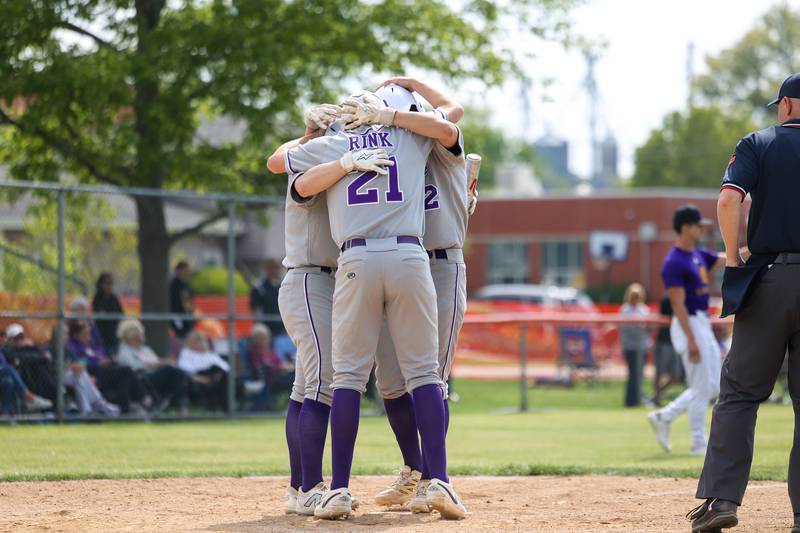 Wilmington's Ryan Kettman, right, Lucas Rink (21) and Dierks Geiss hug at home plate as the Wildcats cement their lead during a 7-2 victory over Chicago Christian in the IHSA Class 2A Beecher Sectional semifinal on Thursday, May 29, 2025.