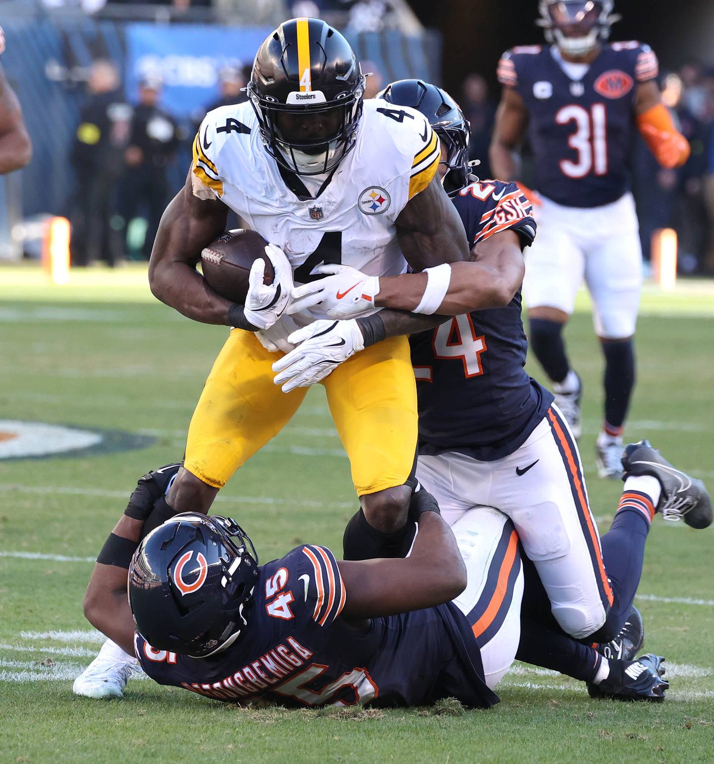 Chicago Bears cornerback Nick McCloud (24) and linebacker Amen Ogbongbemiga bring down Pittsburgh Steelers wide receiver DK Metcalf Sunday, Nov. 23, 2025, during their game at Soldier Field in Chicago.