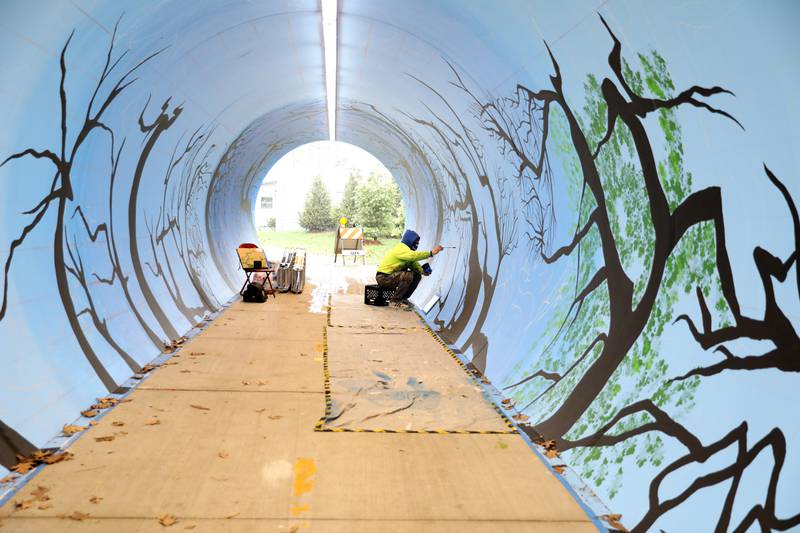 Artist Juan De La Mora works on his mural in the Taylor Avenue pedestrian underpass in Glen Ellyn on Wednesday, Nov. 16, 2022. De La Mora’s piece will feature the four seasons as you progress through the tunnel.