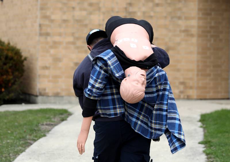 A dummy is carried back into the Fox Valley Career Center for the student paramedics in Maple Park.