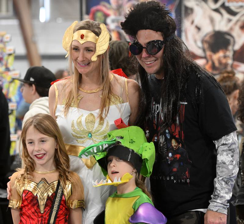 Juliette Janusz, 8, lower left, is dressed as Wonder Woman, her twin sister Cadence is Monti from Five at Freddy’s, Rachel, their mom is She-Ra and their dad, Errol, is dressed as Slipknot during the DuPage Comic Con, presented by Mighty Con, at the DuPage County Fairgrounds, March 2, 2024 in Wheaton. The family stopped at the table of a vendor who asked to take their photo.