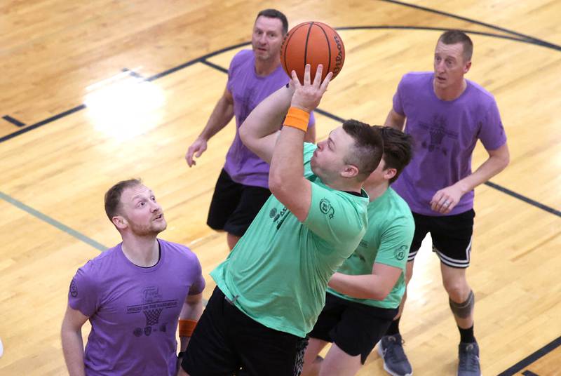 Fire/Police team member Sean Peek shoots over Sycamore School Staff team member Ethan Franklin Thursday, Dec. 19, 2024, during the Heroes on Hardwood basketball game at Sycamore High School. The basketball game, which is a fundraiser for the Sycamore Food Pantry, pits a team of Sycamore first responders against a squad of Sycamore School District 427 staff.