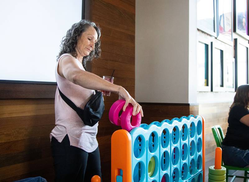 Jennifer Harrington of Minnetonka Minn. plays a giant connect 4 game during the third anniversary of Wahlburgers in St. Charles on July 29, 2023.
