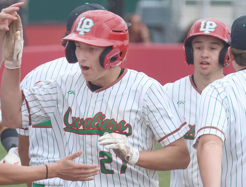 L-P's Grey Ernat and teammate Jett Hill hi-five other teammates after scoring two runs against Morris on Friday, April 17, 2026 at Huby Sarver Field in the L-P Athletic Complex in La Salle.