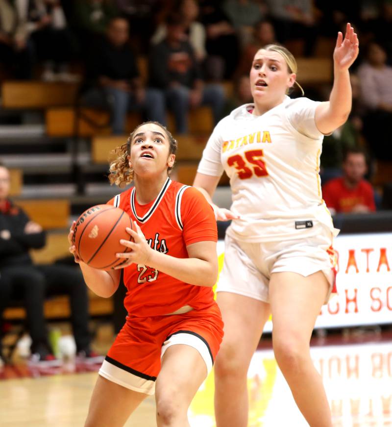 St. Charles East’s Corinne Reed goes up for a shot trailed by Batavia’s Sarah Hecht during a game at Batavia on Thursday, Feb. 1, 2024.