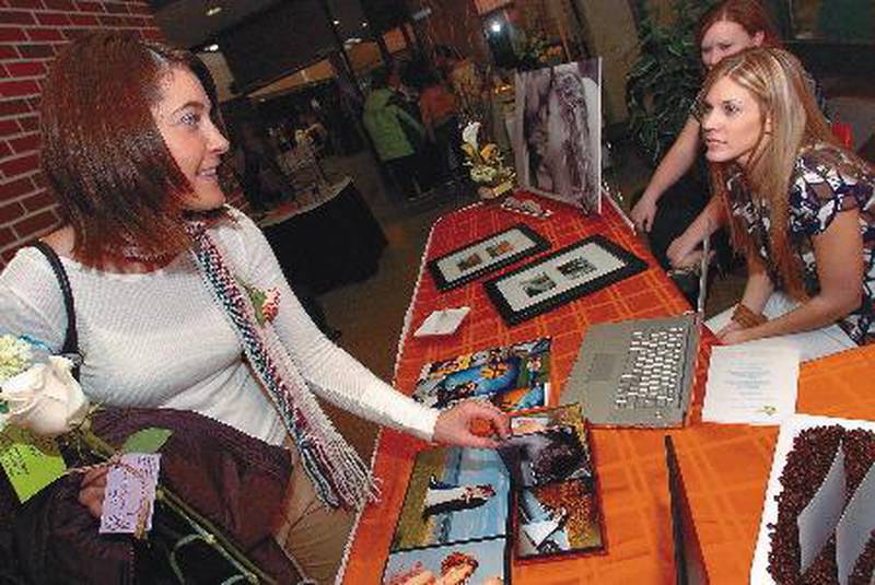 Julie Saunders, left, of Sterling, looks over the portfolio of Morrison photographer Amy Richmond, right, Sunday afternoon at a past Sauk Valley Bridal Fair. More than 40 vendors were on display.