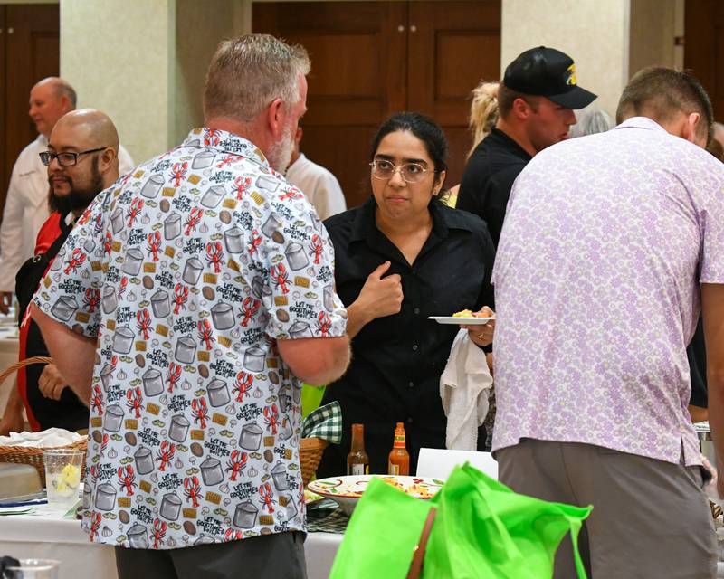 Prathika Mangalagiri, a student pursuing a master’s degree in public health at Northern Illinois University, talks with Brent McConnaughy about his pimento cheese dip appetizer during the 21st annual CASA DeKalb County's Men Who Cook fundraiser held at Northern Illinois University's Barsema Alumni and Visitors Center.