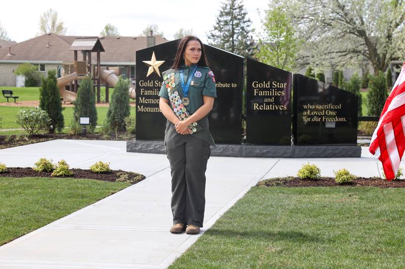 Alexis McCullough, 17, of Bourbonnais, stands in front of the new Gold Star Families Memorial Monument, which she successfully completed for her Eagle Scout project, during the dedication ceremony at Marcotte Park in Bourbonnais on Saturday, April 26, 2025.