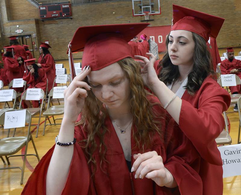 Cassidy Russel helps classmate Rhianna Hansen with her hair Sunday, May 22, 2022, at Streator High School moments before entering Pops Dale gymnasium to receive their diplomas.