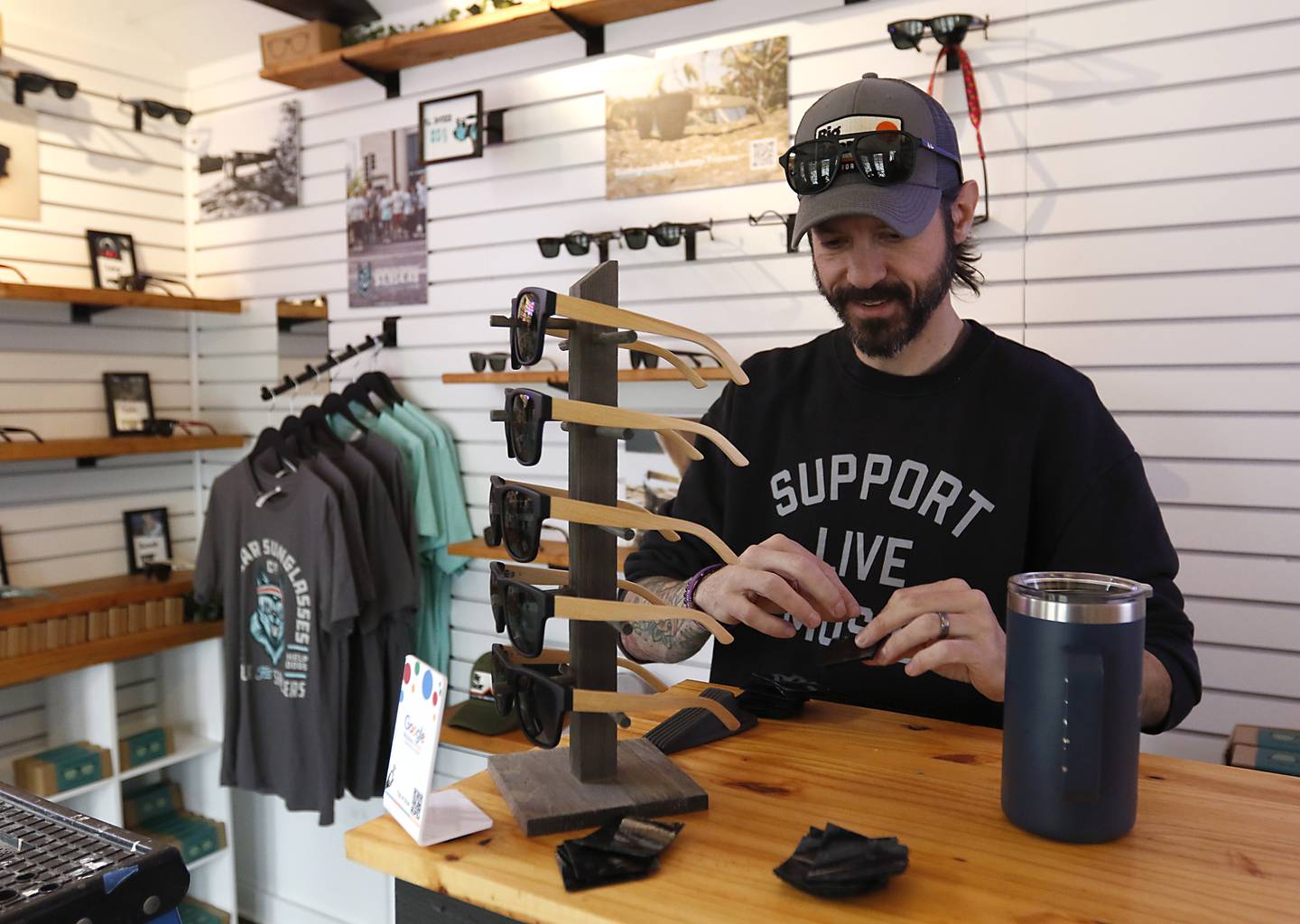 Rick Stiles, the owner of Big Bear Sunglasses, works on setting up his tiny shop on Friday, April 25, 2025, at the McHenry Riverwalk Shoppes. The shops open for the 2025 season on May 2.