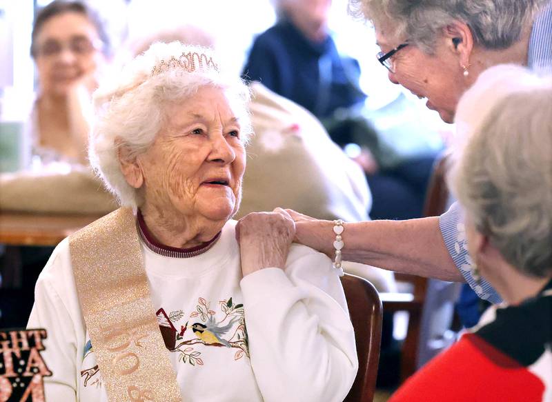 Heritage Woods of DeKalb resident Phyllis Fawcett, is greeted by friends during her surprise 100th birthday party Thursday, March 21, 2024, at Heritage Woods.