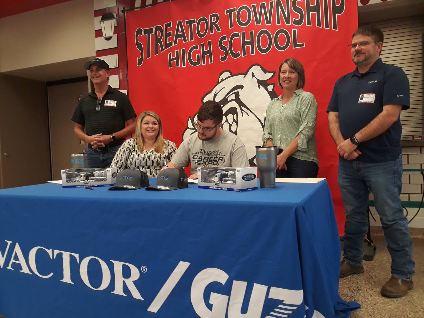 Streator High School senior Carson Trainor signs his letter of intent Tuesday, May 17, 2022, to work at Vactor Manufacturing as (left to right) Tim Hackathorn, painting supervisor at Vactor; Rita Roman, his mother; Rene Barr, human resources generalist at Vactor; and Matt Bouley, production manager at Vactor, look on.