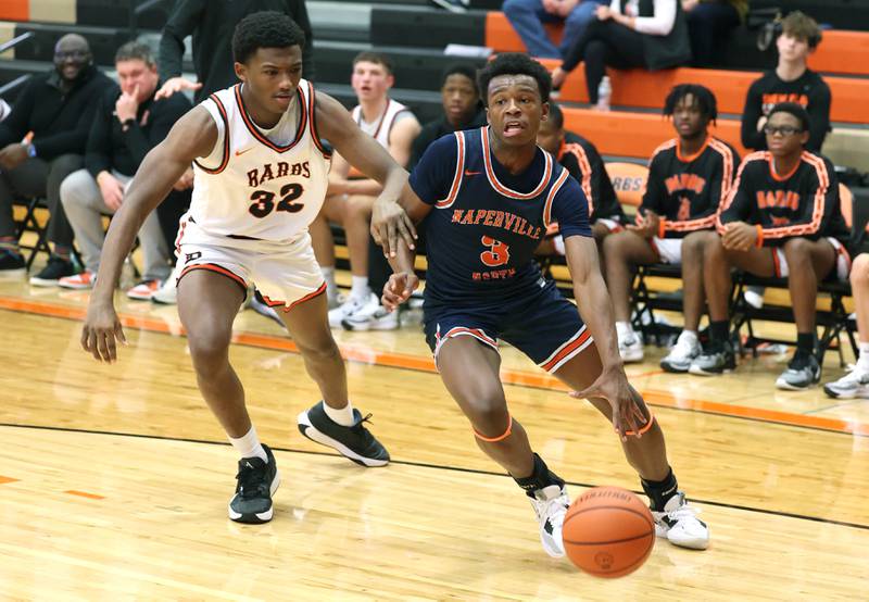 Naperville North's Bryce Welch gets by DeKalb’s Justin O’Neal during their game Friday, Dec. 8, 2023, at DeKalb High School.