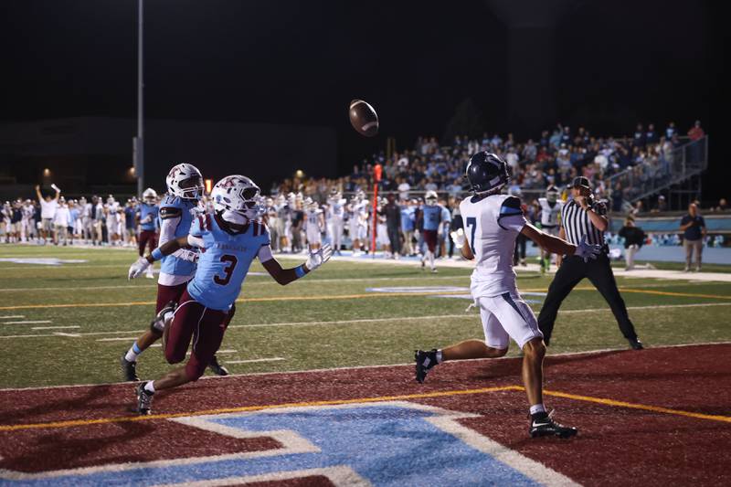 An end zone pass deflects off Nazareth's Jake Cestone, right, as Kankakee's Cedric Terrell reaches to recover it for an interception during Kankakee's 33-12 loss to Nazareth on Friday, Aug. 29, 2025.