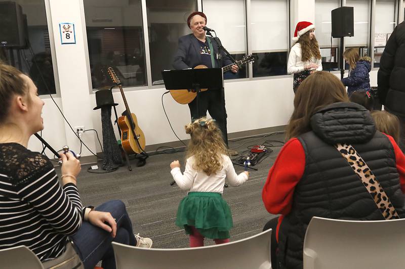 A young fan dances to the music of Andy Huber on Friday, Dec. 2, 2022, during the Very Merry Huntley Holiday Open House at the Huntley Area Public Library. The event featured musical entertainment by Andy Huber, reindeer, Santa, a scavenger hunt, face painting, and a snowball toss.