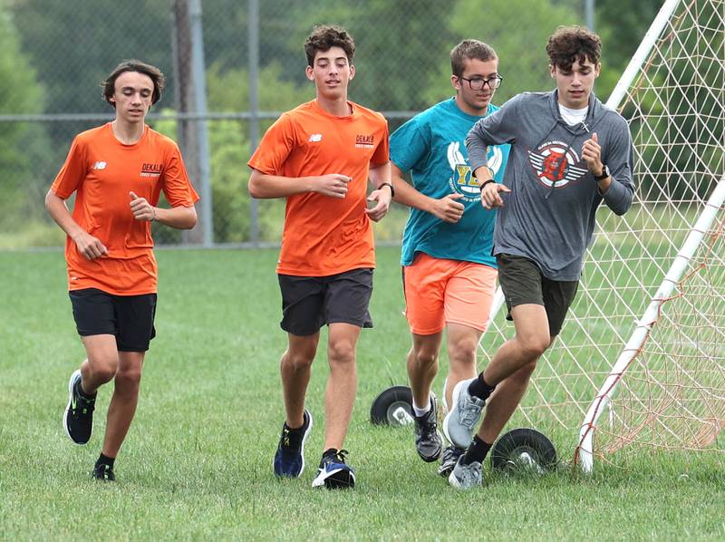 Jacob Barraza (right) runs past a soccer goal with his teammates during practice Monday, Aug. 14, 2023, at DeKalb High School.