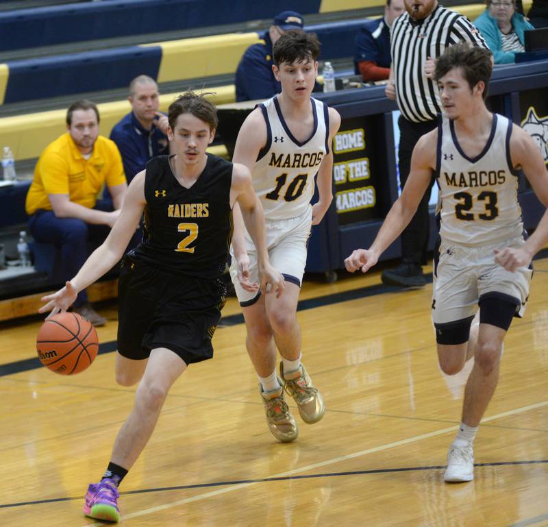 Ashton-Franklin Center's Noah Danielson (left)  heads to the basket as Polo defenders Carter Merdian (center) and Noah Dewey (right) follow on Tuesday, Jan. 2, 2024 at Polo High School.