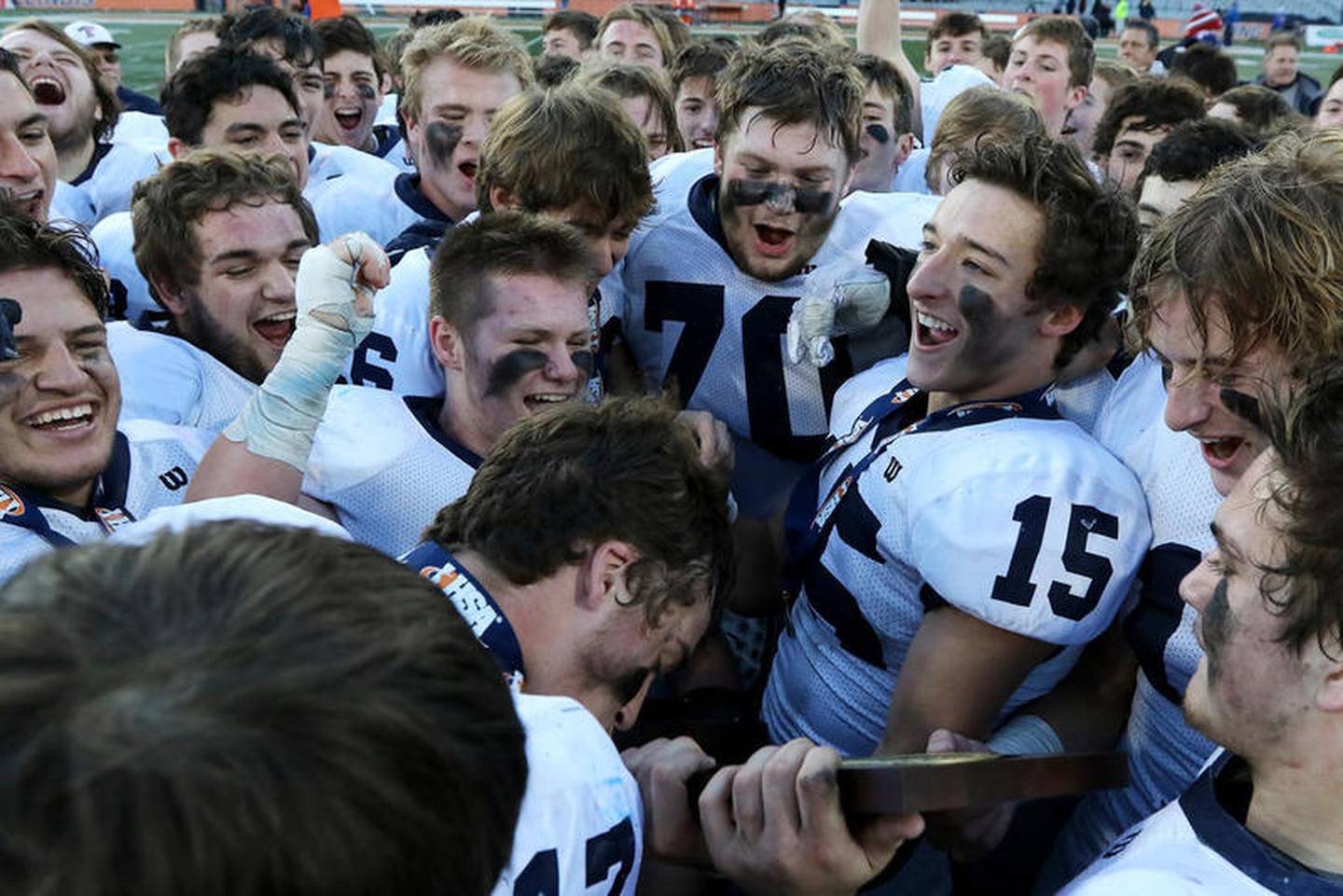 Cary-Grove's Zach Perrone, right, holds the state championship trophy as quarterback Ben McDonald, left, bends over to kiss it after beating Crete-Monee during their IHSA Class 6A state final at Memorial Stadium at the University of Illinois on Saturday, Nov. 24, 2018 in Champaign. Cary-Grove finished off their undefeated season 14-0 with the 35-13 win over Crete-Monee to become 2018 state champions.