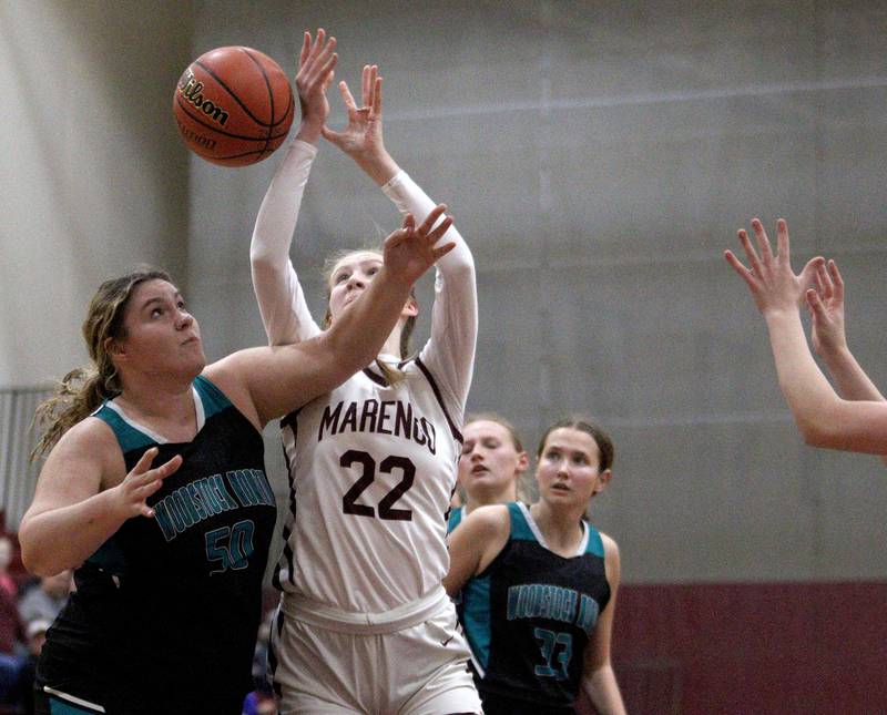Marengo’s Dayna Carr (22) and Woodstock North’s Ashley Janeczko look for a rebound in varsity girls basketball at Marengo Tuesday evening.