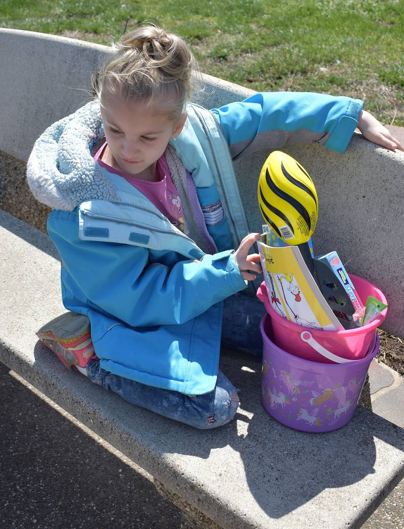 Isabella Portner, 9, of Rock Falls sits on a park bench with her easter basket prize from the Coloma Park District egg hunt on April 12th, 2025.