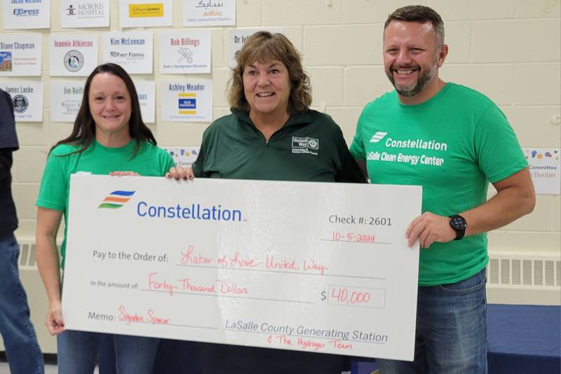 United Way of La Salle County executive director Sally Honiotes (center) accepts a donation of $40,000 from Labor of Love signature sponsor Constellation Energy and its representatives Lisa Elmore and Joe Ward Saturday in Ottawa.