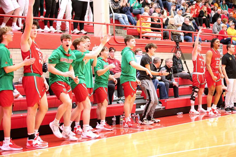 Members of the L-P boys basketball team react after Seth Adams sinks a three point basket over Ottawa in Kingman Gymnasium on Friday, Feb. 10, 2023 at Ottawa High School.