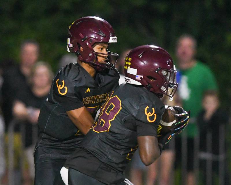 Montini Catholic's Israel Abrams, left, hands the ball off to teammate Isaac Alexander (28) during the game against Fenwick on Friday Sept. 19, 2025, held at Montini High School.