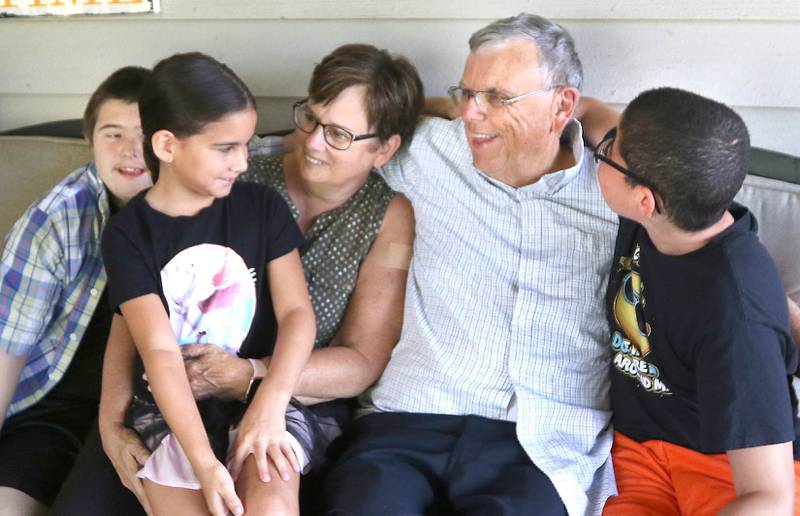 DeKalb County Sheriff Roger Scott and his wife, Marcia enjoy a moment with three of their ten kids David, (left) 15, Evalina, 7, and Ashton, (right) 11, in their DeKalb home Tuesday. Through the years the Scott's have adopted seven children and fostered over 40.