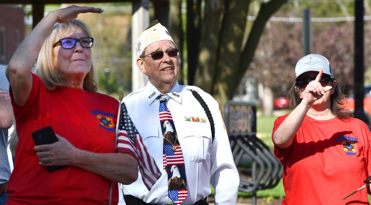 Oregon VFW member Lee Ossmann (center) watches with two VFW volunteers as a banner acknowledging his service is installed on a city light pole on Thursday, April 23, 2026 in downtown Oregon.