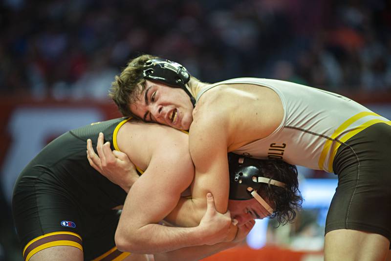 Joliet Catholic's Mason Alessio (top) works against Montini's Jayden Colon during the 2A 145lb finals match at the IHSA state wrestling meet on Saturday, Feb. 19, 2022.