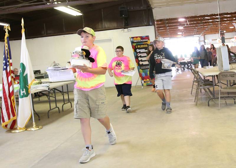 Intermediate 4-H club kids carry foods to be judged through the exhibit hall during the Bureau County 4-H Fair on Thursday, July 13, 2023 in Princeton.
