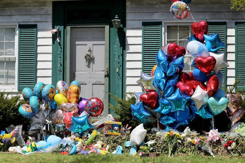 Balloons, stuffed animals, and candles are some of the items left on the front yard to remember the life of Andrew "AJ" Freund at 94 Dole Ave. on Friday in Crystal Lake.