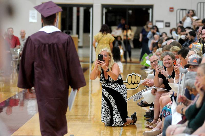 Theresa Baker takes a photograph of a graduate as he walks back to his seat after receiving his diploma Sunday June 5, 2022, during the Marengo Community High School Graduation Ceremony at the school in Marengo.
