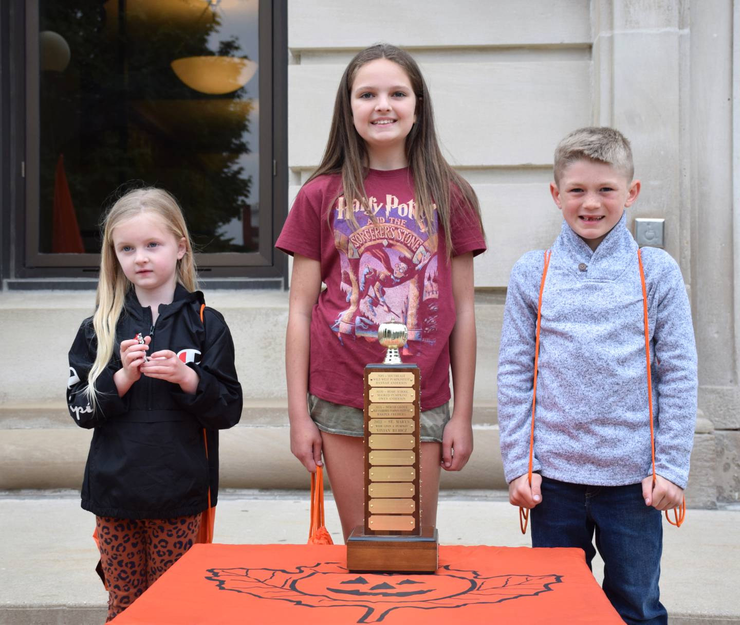 On Wednesday, May 18, the 2022 Sycamore Pumpkin Festival’s theme was announced: “Wish Upon a Pumpkin.” The theme contest winner was Vivian Rubicz, an 11-year-old fifth grader from St. Mary’s School Sycamore. The two honorable mention students are Mason Clark, a first grader from Cornerstone Christian Academy, with the entry “Pumpkins on Vacation,” and Lennox Freeman, a kindergartener from Southeast Elementary School, with the entry “Pumpkin Magic.” From left, Freeman, Rubicz and Clark.