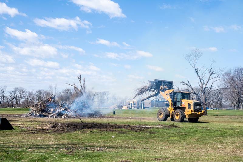 Downed trees are added to a burn pile at the Kankakee Elks Country Club golf course on March 30, 2026, following the March 10 tornado that hit Aroma Township.