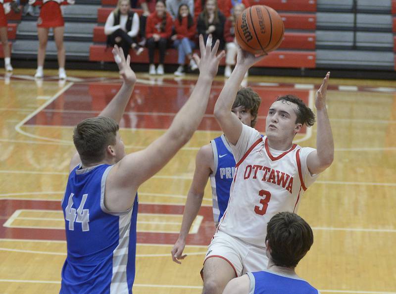 Ottawa’s Levi Sheehan gets a shot off over the block of Princeton’s Bennett Williams in the 2nd period in Kingman Gymnasium on Saturday, Jan. 21, 2023 at Ottawa High School.