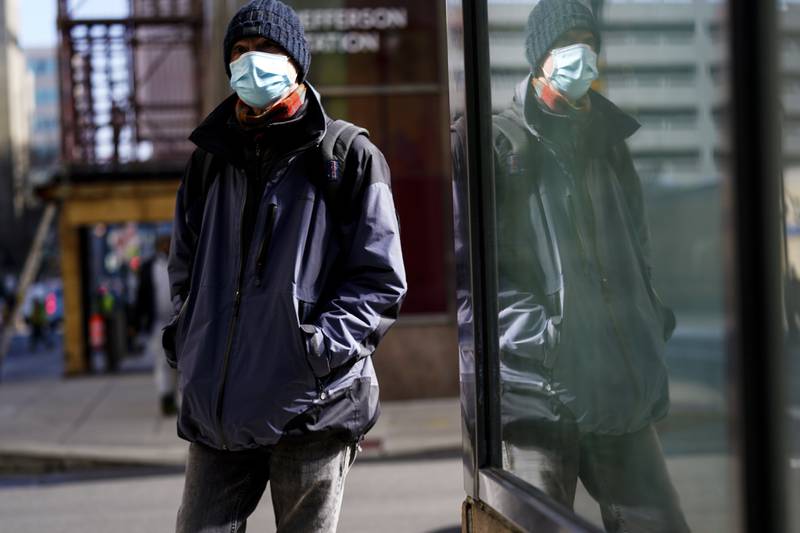 FILE - A person wearing a face masks to protect against the spread of the coronavirus walks in Philadelphia, Feb. 16, 2022. The Biden administration will extend for two weeks the nationwide mask requirement for public transit as it monitors an uptick in COVID-19 cases. The Centers for Disease Control and Prevention was set to extend the order, which was to expire on April 18, by two weeks to monitor for any observable increase in severe virus outcomes as cases rise in parts of the country. (AP Photo/Matt Rourke, FILE