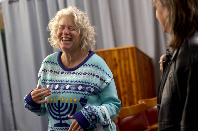 Jaci Krandel of Woodstock shares a laugh with others during a Chanukah party at The McHenry County Jewish Congregation Sunday.