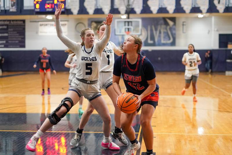 Oswego’s Kendall Grant (42) shoots the ball in the paint against Oswego East's Lillie VanDyke (5) during a basketball game at Oswego East High School on Saturday, January 14, 2017.