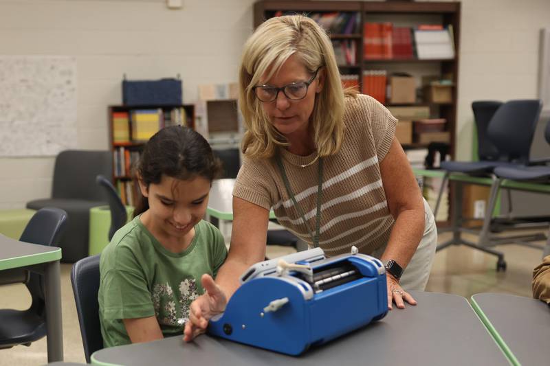 Becky Nahas sets up Giuliana Ciangiola on her Perkins SMART Brailler on the first day of school at Dirksen Junior High School on Wednesday, August 21, 2024 in Joliet.