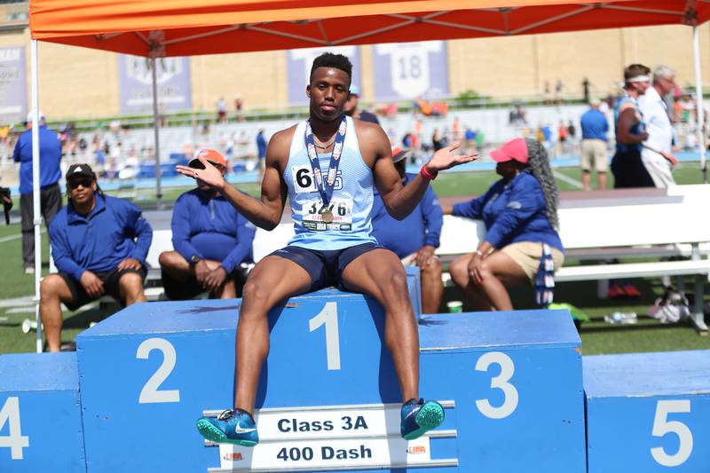 Downers Grove South senior Eli Reed celebrates on the medal podium after winning the Class 3A 400-meter dash at the state track meet in Charleston on Saturday, May 28.