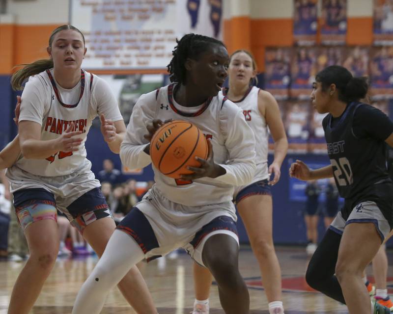 Oswego's Madelyn-Jordan Mensah looks to dribble out after grabbing a rebound during their basketball game between Oswego East at Oswego Friday, Jan 09, 2026 in Oswego.