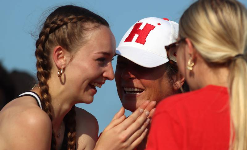 Huntley’s Addison Busam, left, is all smiles as she is encouraged  by coach Jennifer Garza, center, after Busam’s long jump  in IHSA Class 3A Girls Sectional Track and Field Meet action at Red Raider Stadium on the campus of Huntley High School in Huntley on Wednesday, May 14, 2025.