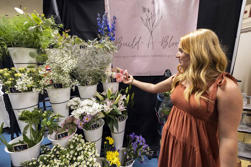 “Build a Bloom” proprietor Olivia Purvis of Prophetstown High School talks about her products Wednesday, April 24, 2024 at the WACC CEO trade show. Purvis is offering make your own bouquets or taking a pre-designed option.