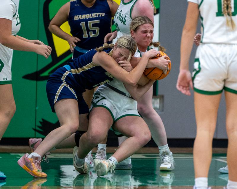 Chloe Thrush (5) of Marquette and Navaeh Corcoran (22) of Seneca fight over possession of ball after rebound under rim on Monday, November 17, 2025 at Seneca High School in Seneca.