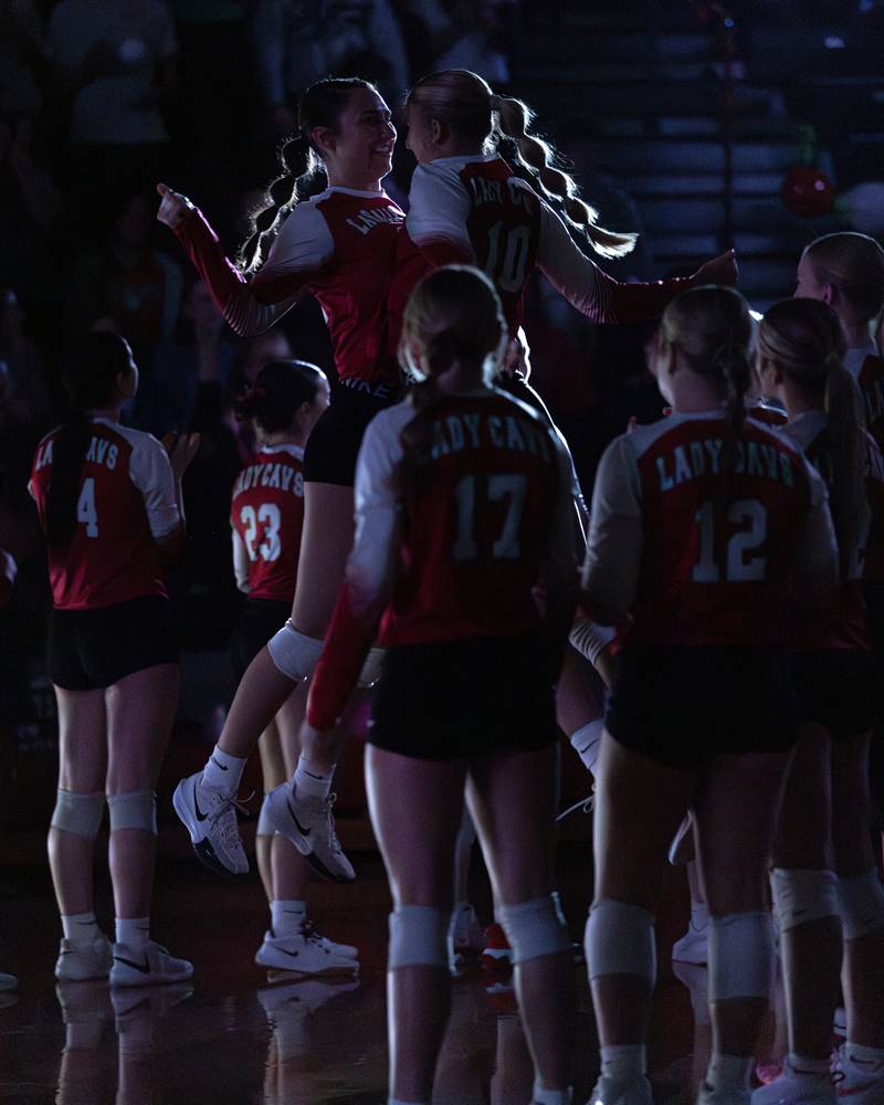 Anna Riva (left) and Kelsey Frederick (right) chest bump during the starting lineup announcement during the match at Sellett Gym on Oct. 15, 2025 at LaSalle-Peru High School.