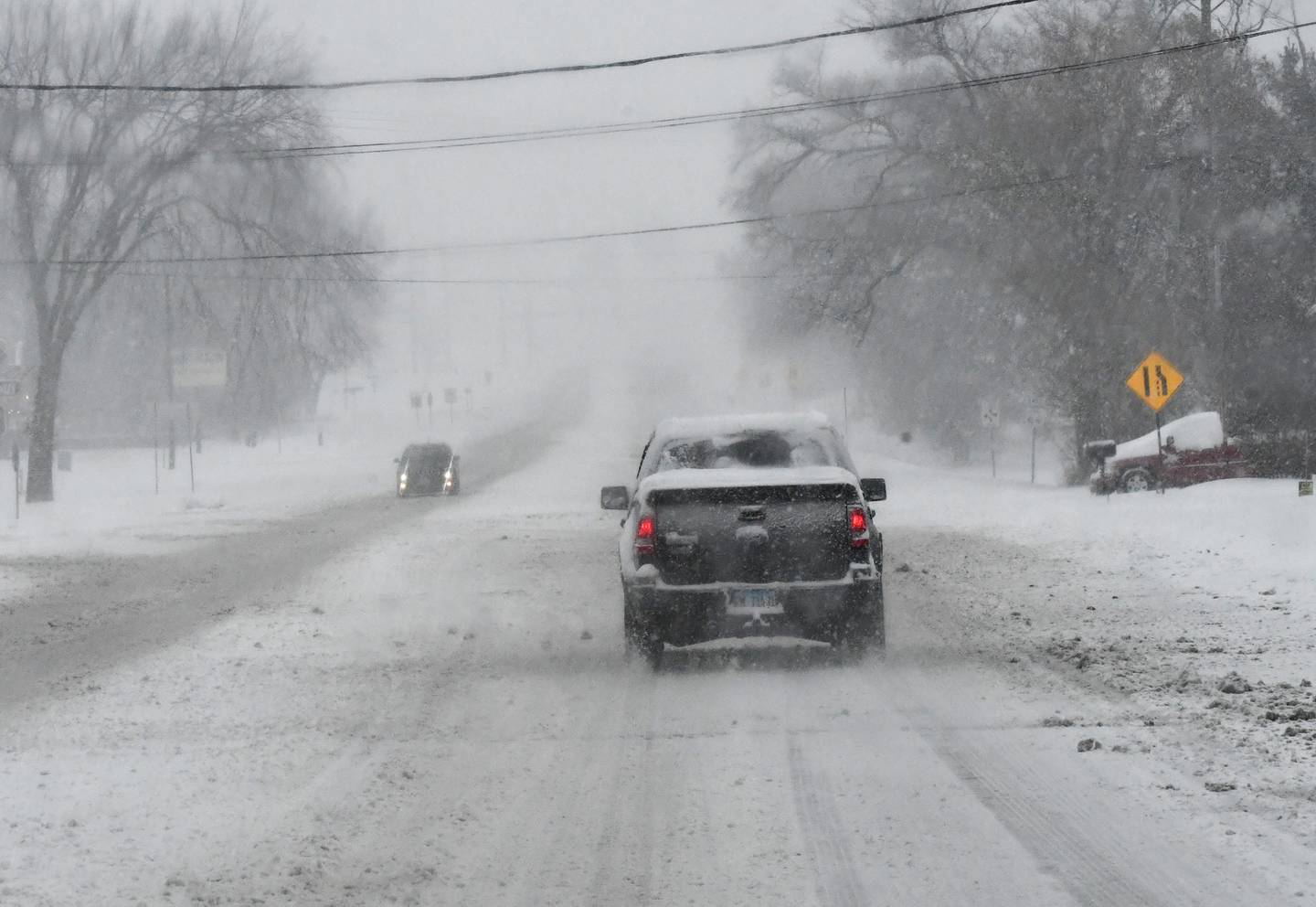 Vehicles travel on Illinois 64 near Oregon on Saturday, Nov. 29, 2025 as several inches of snow fall across the region. Winds were expected to cause drifting throughout the evening making driving more difficult across the region.